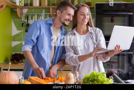 Young happy pair enjoying and preparing healthy meal Stock Photo