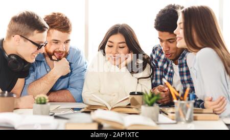 Happy group of students reding book in library Stock Photo