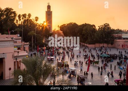 The Minaret of the Kasbah Mosque in the busy Jemaa el-Fnaa at sunset from a patio in Marrakesh, Marrakesh-Safi Morocco. Stock Photo