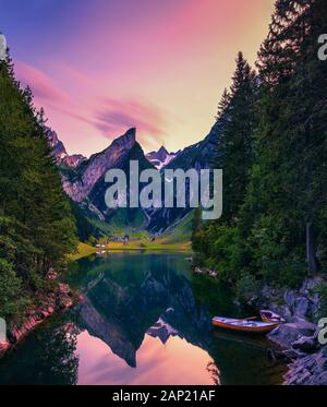 Sunset over the Seealpsee lake with small boats in the Swiss Alps, Switzerland Stock Photo