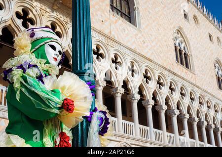 Carnival in Venice. Beautiful Venetian Masks with Doge Palace in the background Stock Photo