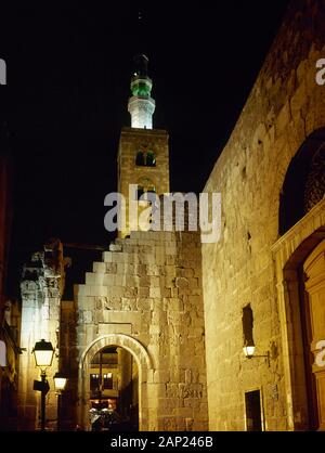 Syrian Arab Republic. Damascus. Night view of one of the streets of the historic center of the city. In the background the minaret of Umayyad Mosque or Great Mosque of Damascus (8th century). Photo taken before Syrian civil war. Stock Photo