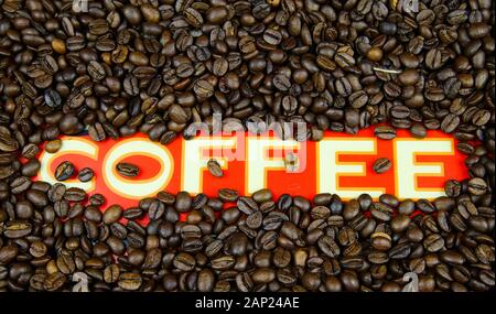 Isolated single word white coffee on red ground with roasted brown countless beans frame Stock Photo