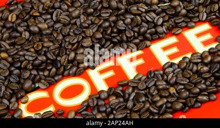 Isolated single word white coffee on red ground with roasted brown countless beans frame Stock Photo