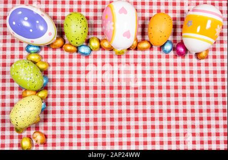 Mix of easter eggs of all colors and sizes on a background of red and ...