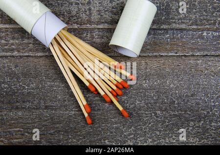 Fire protection and prevention concept: Group of isolated wooden matches with red heads and round matchbox on wood table Stock Photo