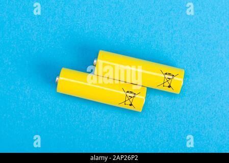 Two yellow batteries on a blue background, top view Stock Photo