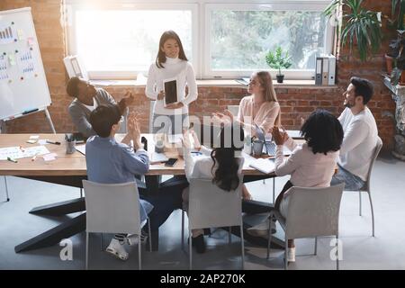 Asian worker making presentation at business meeting, using tablet Stock Photo