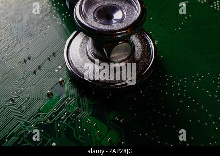 Digital health patient data storage concept - Isolated blue stethoscope on green computer circuit board Stock Photo