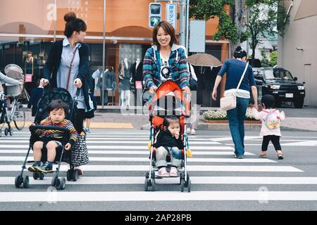 Crossing the street with a baby Stock Photo