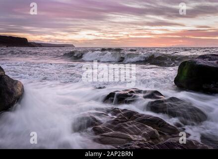 Winter sunset and waves off the Cumbrian coast - UK Stock Photo