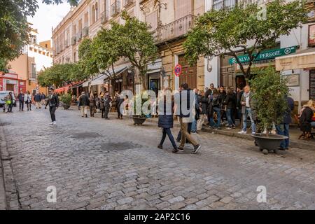 Crowd outside busy spanish tapas bar in winter, Seville, Andalucia, Southern Spain. Stock Photo