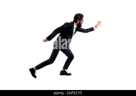 full length portrait of bearded, trendy businessman running isolated on white background, man pulls hand forward to catch something Stock Photo