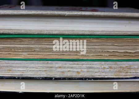 View on isolated pile of antique yellowed books with edges of cover and textblock Stock Photo