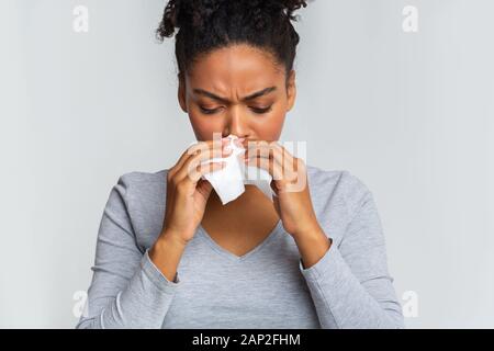 Woman touching her nose with napkin, having runny nose Stock Photo