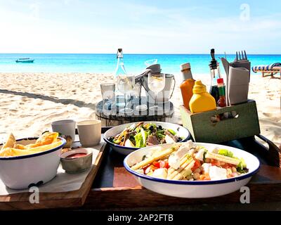 Lunch on the tropical beach on turquoise sea and sand background. Close up. Food summer concept. Stock Photo