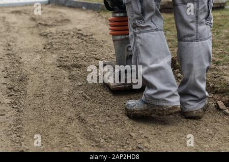 Stamping soil with rammer to build the garden path Stock Photo