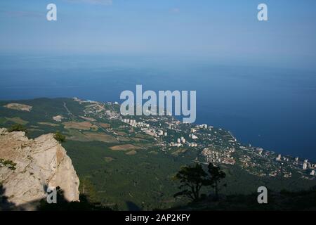 Alpine landscape. View from a high mountain to a small town by the sea. Stock Photo