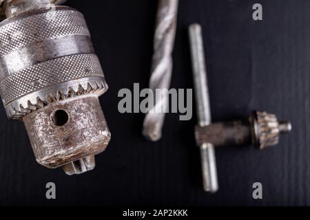 Drill and drills on a workbench. Tools for construction workers. Dark background. Stock Photo