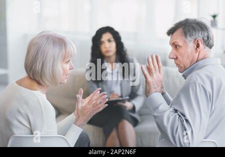 Elderly couple having fight in therapy during session Stock Photo