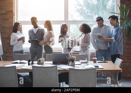 Friendly business team talking while having break Stock Photo
