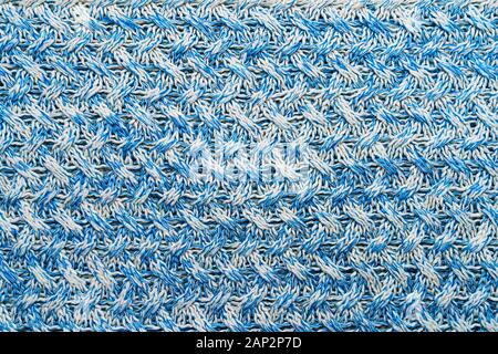 Blue and white texture of a knitted woolen fabric with a patterned weave. Sweater background Stock Photo