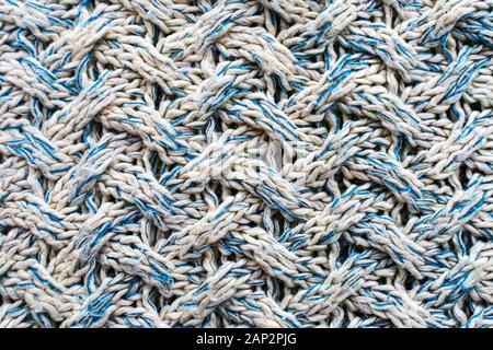 Blue and white texture of a knitted woolen fabric with a patterned weave. Sweater background Stock Photo