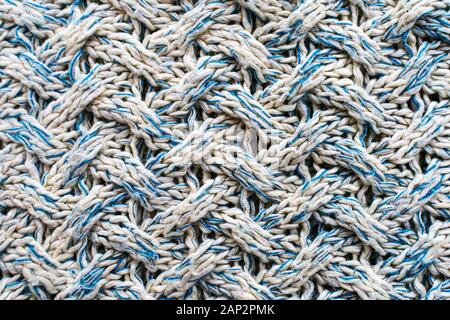 Blue and white texture of a knitted woolen fabric with a patterned weave. Sweater background Stock Photo