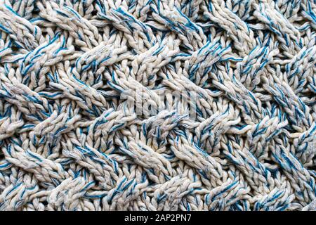 Blue and white texture of a knitted woolen fabric with a patterned weave. Sweater background Stock Photo