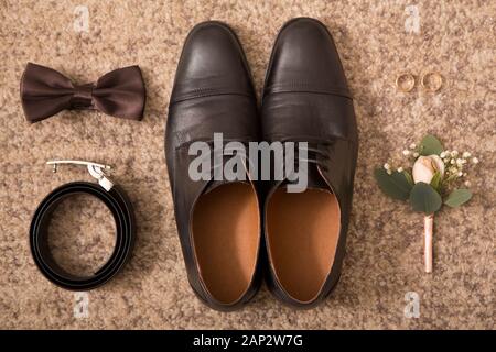 Groom accessories and black shoes on brown floor background Stock Photo
