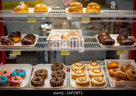 A selection of delicious sweet donuts for sale in a cafe in Christchurch city, New Zealand Stock Photo