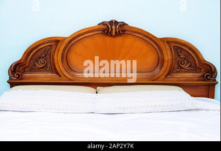 Decorative wooden double bed with two pillows and blankets Stock Photo