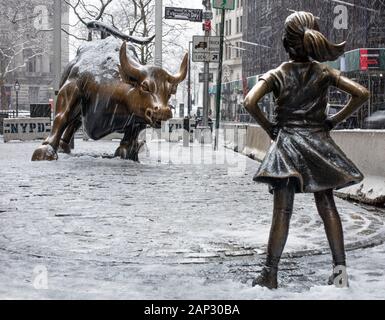 Fearless Girl statue in previous position in front of Wall Street Charging Bull Stock Photo