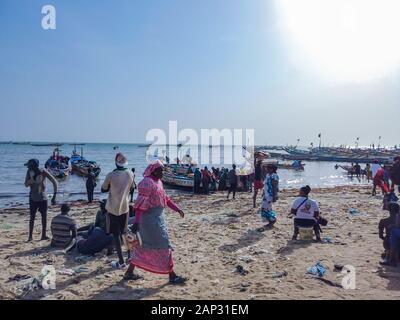 MBour, Senegal- April 25 2019: Unidentified Senegalese men and women at the fish market in the port city near Dakar. There are stalls selling and Stock Photo