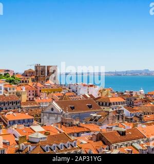 Lisbon rooftops and Santa Maria Maior de Lisboa cathedral with river Tagus on a background viewed from Santa Justa lift viewing platform. Stock Photo