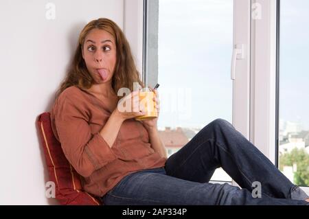 Mädchen am Fenster schneidet Grimasse - Girl At The Window doing a Grimace Stock Photo