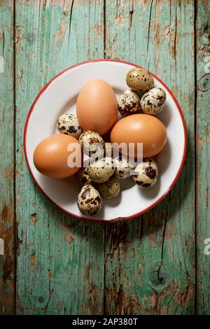 Quail and chicken eggs on a wooden table. Stock Photo