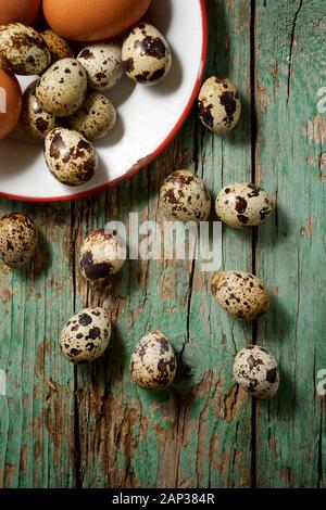 Quail and chicken eggs on a wooden table. Stock Photo