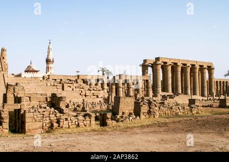 Egypt,Luxor, Luxor Temple,معبد الاقصر; Thebes. Piles of archaeological finds used in the reconstruction of the temple. Mosque of Abu el-Haggag behind. Stock Photo
