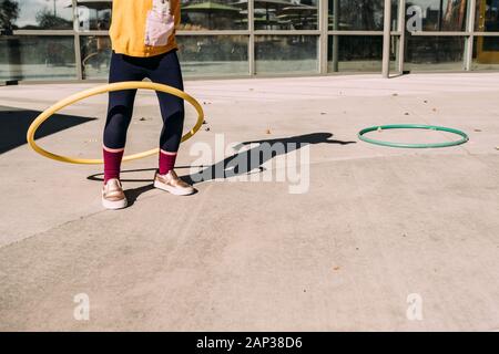 girl hula hooping on a patio on a summer day Stock Photo