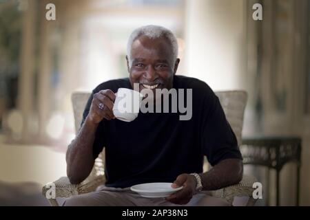 Portrait of a smiling mature adult man drinking tea. Stock Photo