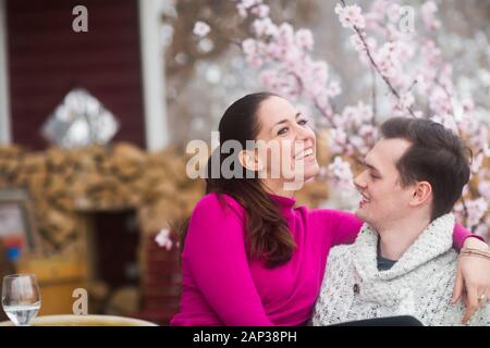 young couple sitting together with blooms Stock Photo