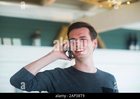 young man wit smartphone standing in room Stock Photo