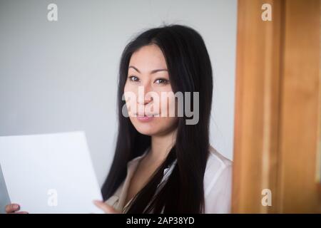 young woman at home with paper Stock Photo