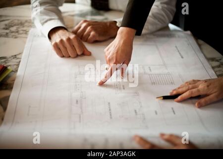 People working on architectural blueprint. Stock Photo