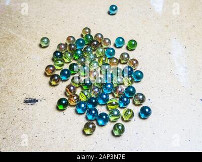 Colored glass balls scattered on wooden surface Stock Photo