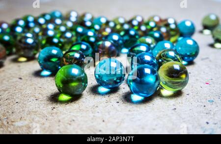 Colored glass balls scattered on wooden surface Stock Photo