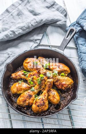 Roasted chicken legs in pan with herbs - close up Stock Photo