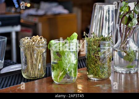 Bar tenderer bartender cutting items to add to hard liqueur drinks at outside bar Stock Photo