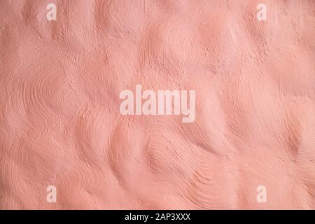 Living Coral color of the Year 2019 on abstract background or decorative texture of old stucco wall, plaster. Home decor. Stock Photo